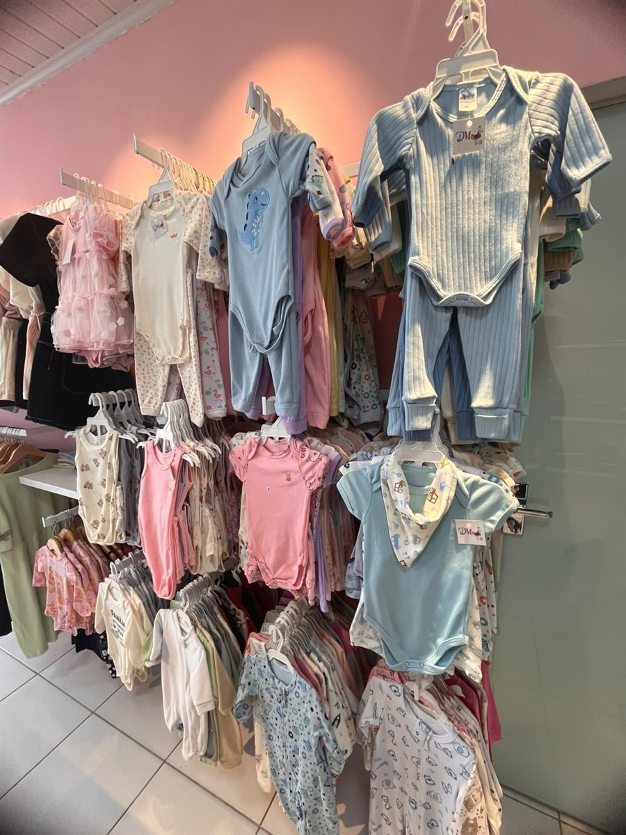 Roupinhas de bebê penduradas na loja DM Kids